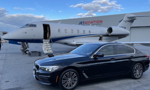 A bmw series 5 waiting at private jet at FBO airport.